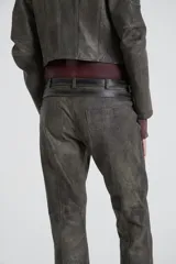 Pantalón de cuero color gris con tiro bajo, bolsillos delanteros con labio y cierre metálico oculto, pierna con recortes en delantero y pinza en espalda.