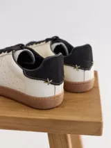 Championes urbanos de cuero color plateado con puntera de gamuza azul y cordones blancos.