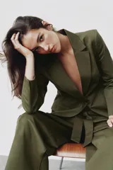 Blazer verde militar entallado con cuello de solapa, manga larga, cierre frontal de un botón y bolsillos con solapa.
