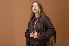 Campera de cuero marrón oscuro con diseño de flecos largos en el frente y las mangas. Presenta un corte recto, cierre frontal con cremallera y cuello clásico, con un estilo inspirado en la estética western.