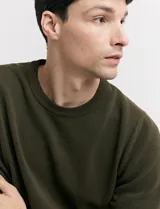 Remera de punto color beige, de manga corta y cuello redondo.