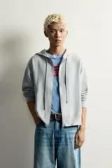 Sudadera hoodie relaxed fit de punto color gris, confeccionada en hilatura con viscosa de tacto suave, con cuello con capucha ajustable, manga larga, cierre frontal con cremallera y acabados en rib.