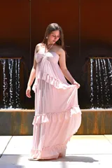 Vestido largo color rosa, con escote halter, corte imperio, falda con volados y espalda descubierta.