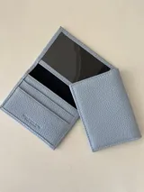 Tarjetero de cuero vacuno color dorado, con ranuras para tarjetas y bolsillo exterior en la parte trasera. Marca Bretoni.
