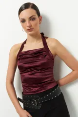 Top negro de satén con cuello halter y espalda descubierta.