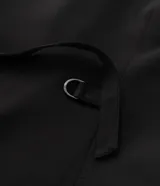 Chaleco sastre de corte alargado, color negro, con escote en V profundo y diseño sin mangas. Presenta un estilo minimalista con bolsillos laterales simulados y ajuste entallado en la espalda.