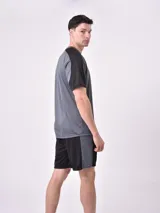 Remera deportiva gris oscuro con mangas cortas negras y logo pequeño estampado en el pecho.