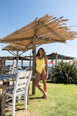 Malla enteriza color amarillo con escote redondo, breteles anchos y espalda baja. Diseño clásico con cobertura de pierna media.