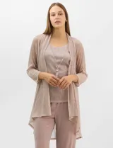 Conjunto de tres piezas compuesto por una musculosa recta, un cardigan liviano de frente abierto con mangas 3/4 y un pantalón de seda fría. La musculosa y el cardigan están confeccionados en tejido plisado con hilos metalizados tornasolados. Incluye collar removible y forro interno a tono.