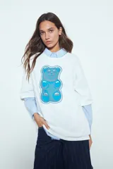 Remerón de manga corta con calce amplio y estética urbana, confeccionado con proceso de lavado que le otorga un efecto desgastado. Presenta una estampa gráfica frontal de un oso de goma en color verde.