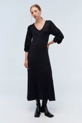 Vestido largo negro con sutiles detalles de lurex azul, escote en V y mangas largas.