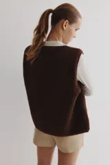 Chaleco de sherpa suave color marrón, con cierre frontal, ribetes de cinta finos y dos bolsillos de parche en la parte delantera. Forrado.