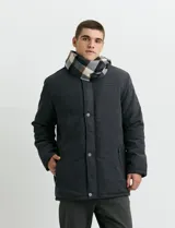 Campera de abrigo color verde oscuro, con cierre frontal oculto por solapa con botones, bolsillos laterales con cierre y cuello alto.