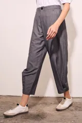 Pantalón gris a rayas verticales blancas, de corte recto y tiro medio.