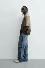 Camiseta de corte relajado (relaxed fit) con cuello redondo y manga corta. Presenta un estampado frontal con relieve en la zona del pecho con el texto "Endless Echo", y un efecto de teñido degradado que va del marrón claro al marrón oscuro/negro en la parte inferior.