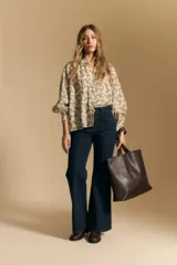 Jean oxford de tiro alto, color azul oscuro, con costuras frontales marcadas y corte acampanado progresivo desde la rodilla.