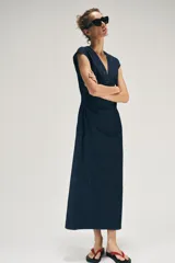 Vestido midi de denim azul oscuro, con escote en V, mangas cortas y detalles de entredoses en el escote y la cintura. Cuenta con cierre trasero con cremallera oculta.
