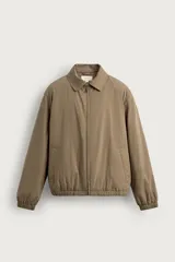 Cazadora regular fit de tejido técnico color verde militar, con mezcla de algodón ligeramente acolchado en su interior. Cuenta con cuello solapa, manga larga, bolsillos de vivo en la cadera, acabado con elástico y cierre frontal con cremallera.