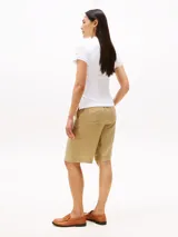 Chomba blanca de manga corta con cuello tipo polo y cartera de dos botones. Presenta el logo script de Tommy Hilfiger bordado en azul marino en el pecho.