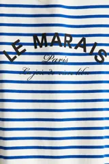 Remera de manga corta con cuello redondo, confeccionada en tejido de punto a rayas horizontales blancas y azules. Presenta un estampado frontal con texto en negro que incluye "LE MARAIS" y "Paris".