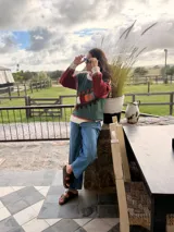 Sweater de punto color crema con diseño geométrico en tonos marrones, naranjas, verdes y grises en el pecho y las mangas. Confeccionado con lana y cuero, con detalles tejidos y bordados a mano.