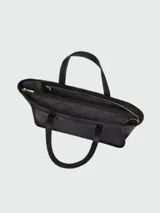 Cartera tipo tote de cuero negro con textura granulada, diseño minimalista, asas largas para hombro y compartimento principal amplio.