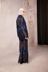 Camisa de corte oversize y holgado, confeccionada en una combinación de tela azul con superposición de encaje negro. Presenta mangas largas, cuello clásico y cierre frontal con botones transparentes.