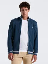 Campera deportiva azul marino de tejido doble con cierre frontal, cuello alto y bolsillos laterales. Presenta rayas blancas en el pecho, hombros y puños, y logo bordado de la marca en el pecho.