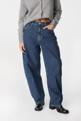 Jean de corte wide leg y tiro alto, confeccionado en denim azul con sutil textura rayada vertical. Presenta diseño de cinco bolsillos, cierre frontal con botón y costuras reforzadas.