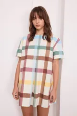 Vestido corto de algodón color negro, con mangas cortas, cuello redondo y diseño con tablas frontales y traseras que le otorgan una caída holgada.