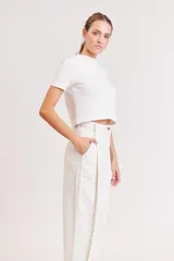 Pantalón de jean color crudo, de corte recto y tiro alto, con diseño de pinzas frontales y bolsillos laterales.