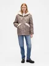 Campera acolchada color beige con diseño de costuras onduladas, cierre frontal, capucha y bolsillos frontales con detalles en corderito blanco.