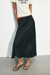 Falda midi de corte recto confeccionada en tejido satinado con acabado brillante, tiro alto y cintura elástica.