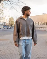 Canguro con capucha color gris oscuro, con cierre frontal y bolsillos tipo canguro.