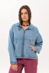 Campera de jean color celeste con silueta relajada y calce amplio. Presenta cierre frontal metálico, cuello clásico y bolsillos laterales.