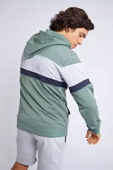 Canguro con capucha y cordón ajustable, de diseño color block en tonos verde, gris y azul marino. Presenta un bolsillo frontal tipo canguro y el logo de la marca bordado en el pecho.