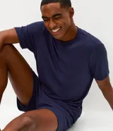Conjunto de pijama masculino compuesto por una remera de cuello redondo y mangas cortas, y una bermuda con cintura elástica. Presenta un diseño liso en color azul marino con textura acanalada.