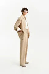 Pantalón largo de corte recto y calce relajado en color beige. Presenta cintura elástica con cordón ajustable y bolsillos laterales. Confeccionado en una mezcla de tencel y algodón.