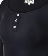 Blusa de pijama manga larga color blanco, confeccionada en tejido rib acanalado. Presenta cuello redondo con cierre frontal de tres botones y ajuste al cuerpo.