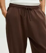 Pantalón jogger de pijama color negro, confeccionado en tejido de modal con mezcla de poliéster y elastano. Presenta cintura elástica con cordón de ajuste, bolsillos laterales y puños ajustados en el ruedo.