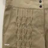 Pantalón verde militar tornasolado de algodón brillante, corte a la cintura y piernas rectas con textura de tableado central.