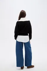 Sweater negro de viscosa con diseño holgado, cuello asimétrico y mangas largas.