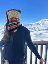 Pasamontañas tejido a mano de lana con diseño étnico y geométrico en tonos negro, blanco, naranja y turquesa.