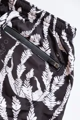 Short de baño negro con estampado de sirenas blancas y plantas marinas.