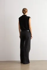 Jean estilo wide leg de tiro medio, color negro, confeccionado en denim con apliques de brillos en los laterales.
