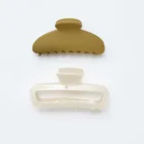 Set de dos pinzas para el pelo tipo cangrejo, una de color verde mate y otra de color crema con textura craquelada.