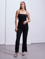 Mono largo negro de crepe con escote recto y breteles finos. Cierre invisible en la espalda.