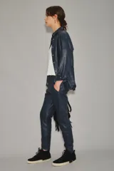 Babucha de cuero ovino color azul marino, con bolsillos frontales y cintura elastizada con tira de ajuste del mismo cuero y terminales metálicas.