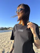 Remera color crema de algodón con estampa en la espalda de un paisaje playero con el texto "Chema Sure Chate et la mer".