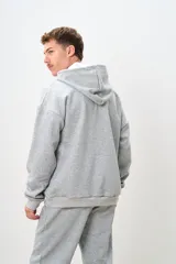 Canguro gris melange con capucha, cordones ajustables, bolsillo tipo canguro y puños y cintura acanalados.